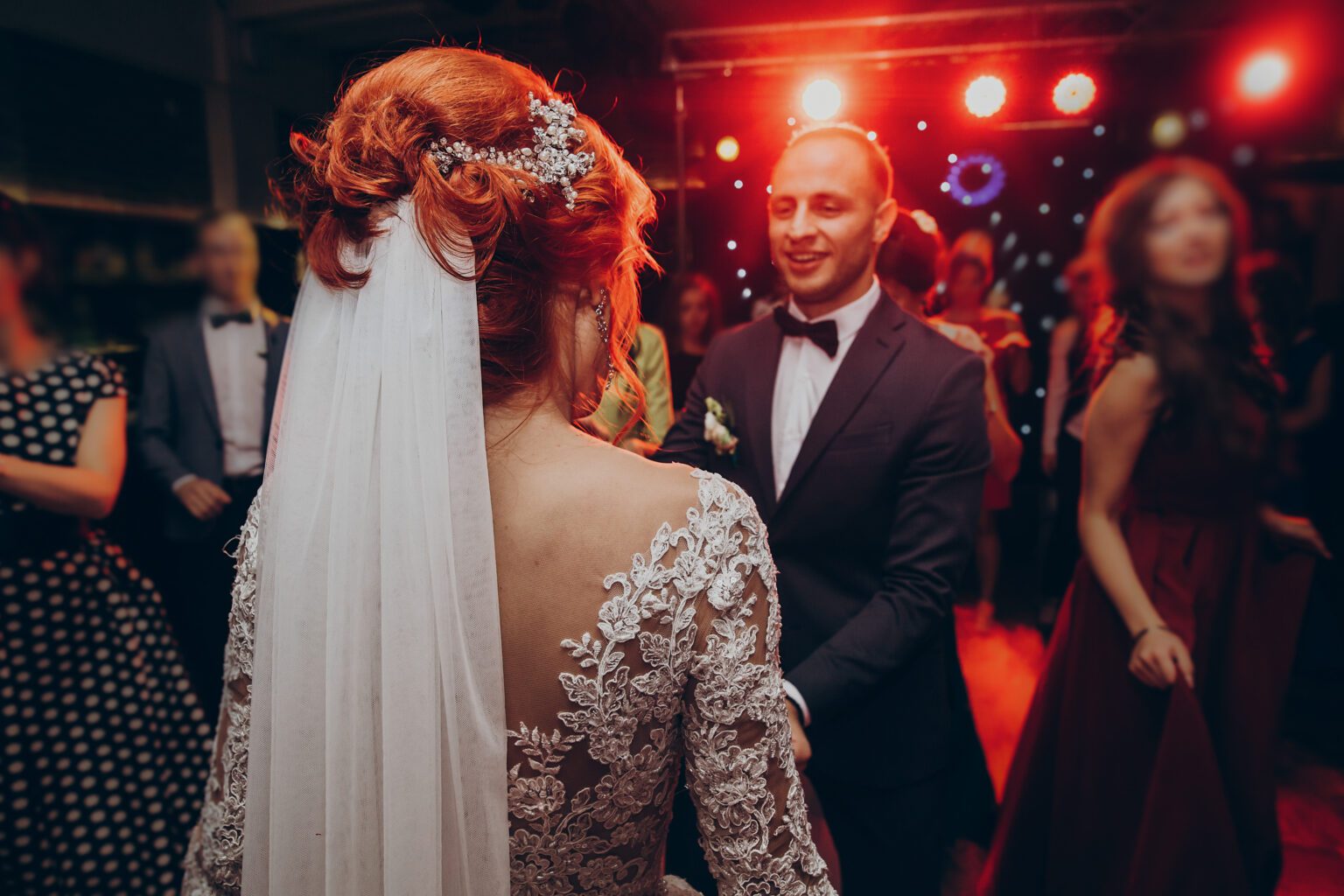 Gorgeous wedding couple having fun and partying in restaurant in happy bride and stylish groom dancing at wedding reception. gorgeous wedding couple having fun and partying in restaurant in light show. newlywed emotional moment.